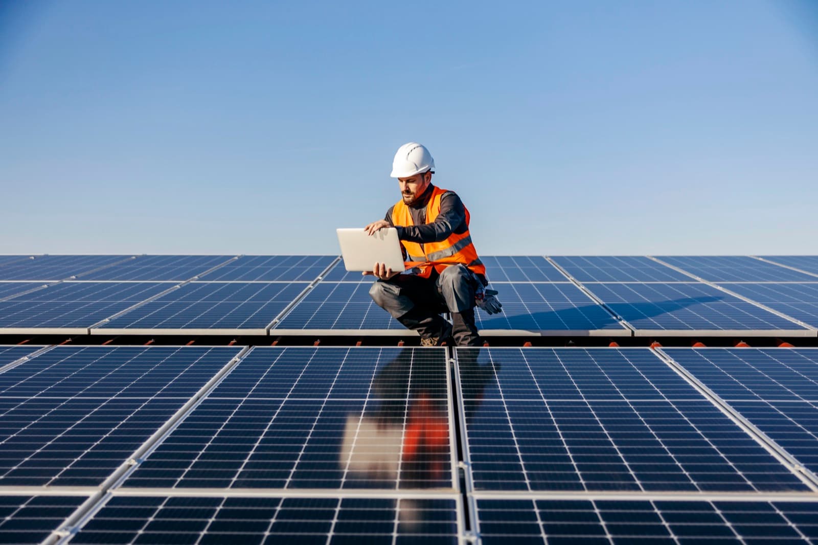 Solar installer working on a rooftop array at a California job site